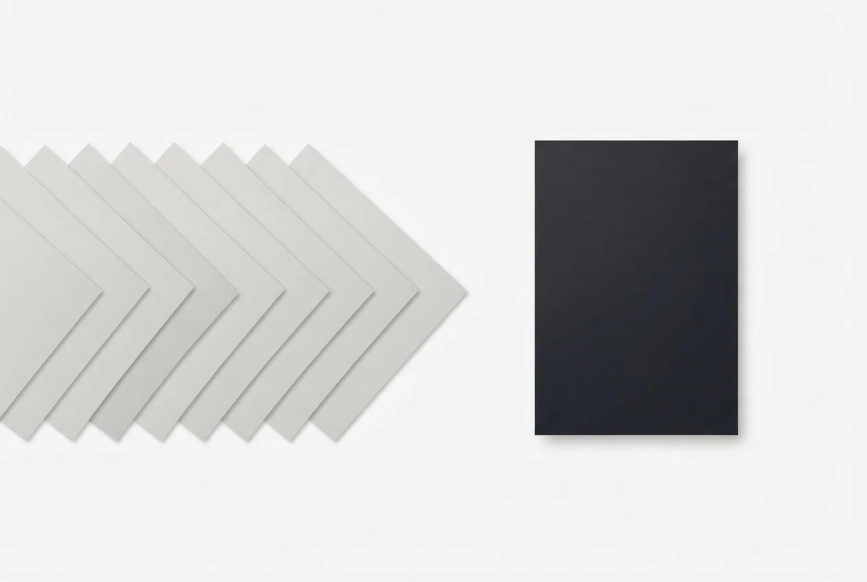 A row of ten identical grey sheets of paper beside one darker sheet that stands apart.